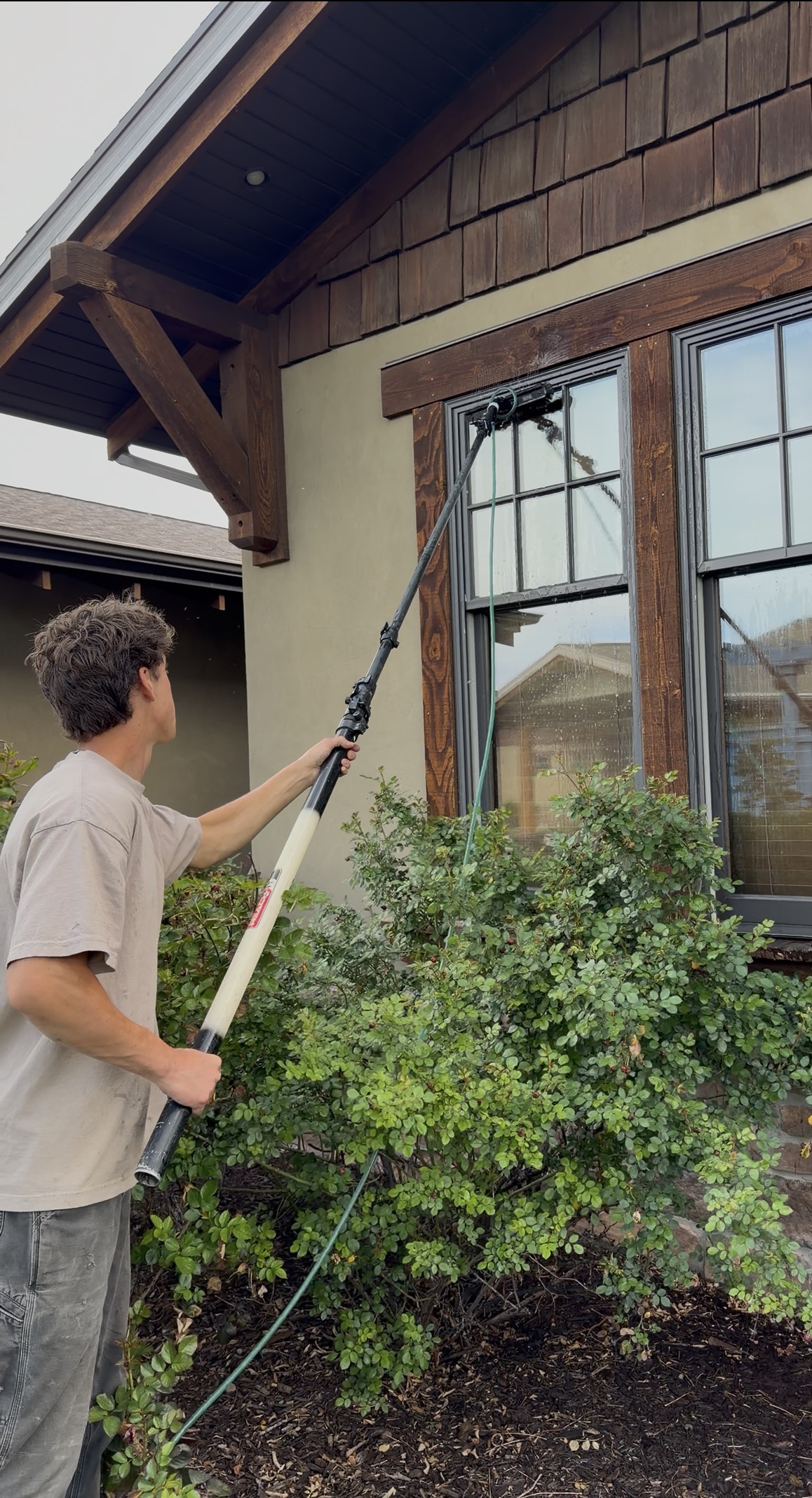 Dab crew cleaning a window with a water-fed pole on a Utah County home